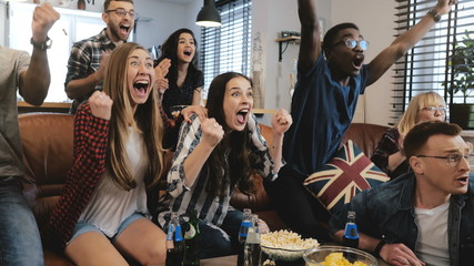 Emotion. Multi-ethnic fans celebrate winning. Confetti 4K slow motion. Passionate supporters shout...
