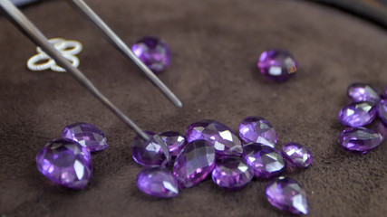Gems being held by a tweezer on the desk
