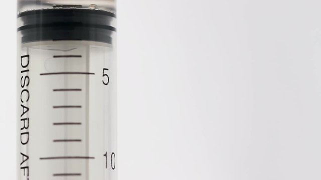 Clear liquid being resorbed into big syringe. saline solution flows inside tool
