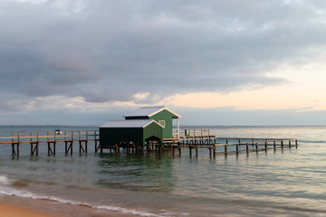 An empty coastline with green boathouse.