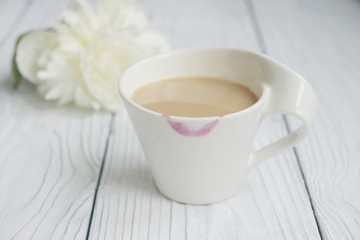 White cup of coffee on a white table with traces of lipstick