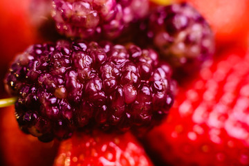 Top view of fresh background with raw strawberries and mulberries.