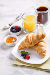 Breakfast served with croissants, coffee, orange juice and berries.