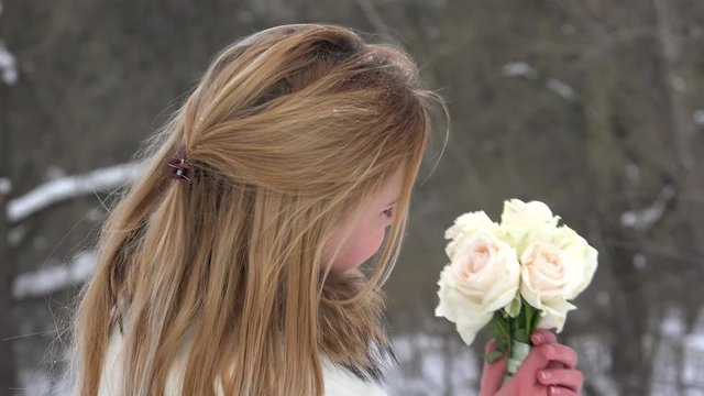 Pretty girl with a bouquet of white roses at early spring.