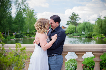 Bridal wedding plus size couple woman and man sitting with heads together on park.    