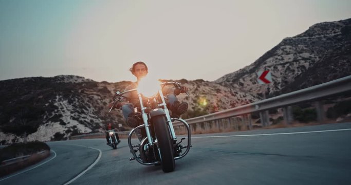 Crew of rebel motorcycle riders on mountain highway at sunset