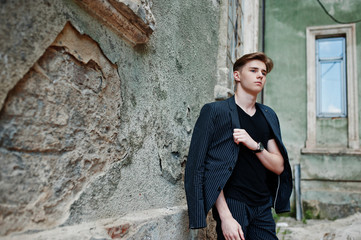 Young stylish macho boy in black jacket posed outdoor of street. Amazing model man.