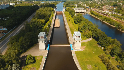 Sluice Gates on the River. Aerial view barge, ship in the river gateway. River sluice construction, water river gateway. Shipping channel.