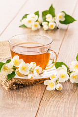 Obraz na płótnie Canvas Glass cup of green tea with white jasmine flowers