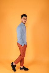 Fototapeta na wymiar Fashion man posing in studio.Handsome man on yellow background.Studio shot of young handsome Indian man wearing stylish clothes against yellow background