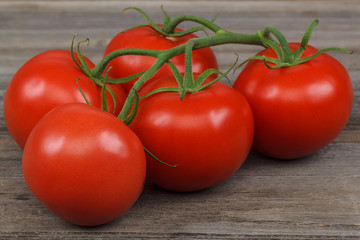 Branch fresh red tomato on a wooden background