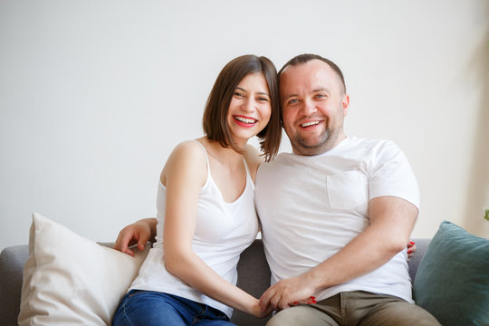 Image of young married couple sitting on sofa