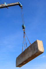 Obraz premium Żuraw ładuje stare bloki betonowe na placu budowy
