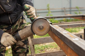 Worker cuts metal for doors at a construction site