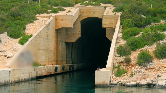 Old abandoned concrete hiding bunker for military ships on Croatian island. Filmed on sailing trip in Croatia in slow motion hd.