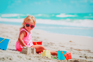 cute little girl play with sand on beach