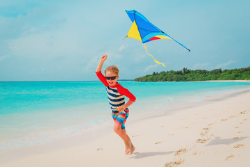Little boy flying a kite on tropical beach