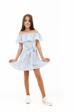 Full length image of Happy young brunette girl in dress