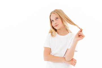 Pensive young blonde girl in casual clothes touching her hair