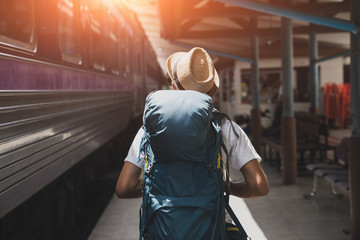 Young asian traveler with backpack in the railway, Backpack and hat at the train station with a...