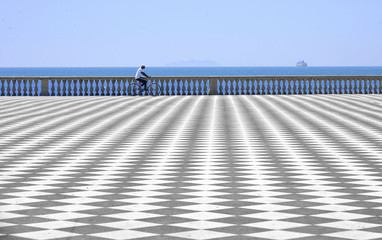 abstract patterns in open terrace Mascagni facing the sea in Livorno with man passing in bycicle, Italy