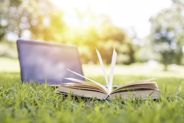 book and notebook on green grass, learning and knowledge concept