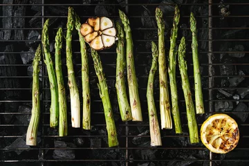  Grilled vegetables green asparagus, garlic, lemon on bbq grill rack over charcoal. Top view, space. © Natasha Breen