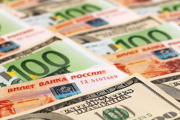 Fototapeta na wymiar Euro banknotes, US dollars, Russian rubles are lying on the table in a shuffle