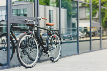 Fototapeta na wymiar comfortable bicycle reflected in modern building on empty street