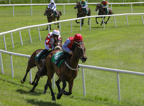 Horses and jockeys racing on the track