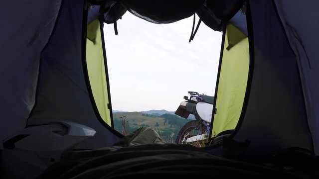 Landscape outside tent view mountans, enduro motorcycle travel, dual sport helmet, sleeping bag, morning at the top of the mountain, camping travel motorcycle touring adventure, off road road trip