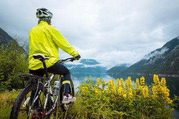 Mountain bike cyclist near fjord, Norway