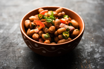 Boiled Peanut Chaat or Chatpata sing dana or shengdana or mungfali. served in a ceramic bowl over moody background - obrazy, fototapety, plakaty