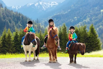Wandaufkleber Kinder reiten Pony. Kind auf Pferd in den Alpenbergen © famveldman