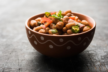 Boiled Peanut Chaat or Chatpata sing dana or shengdana or mungfali. served in a ceramic bowl over moody background - obrazy, fototapety, plakaty