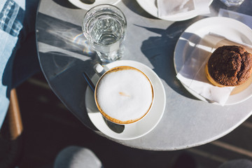 Coffee with a cookie on the table from above