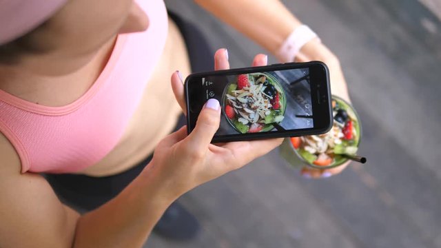 Fitness Woman In Sports Clothes Taking Picture Of Healthy Green Smoothie With Smartphone