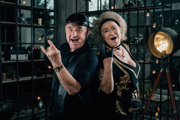 Obraz na płótnie Canvas Happy couple of retirees in biker clothes.old crazy face grandmother.Merry pensioners