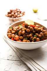 Boiled Peanut Chaat or Chatpata sing dana or shengdana or mungfali. served in a ceramic bowl over moody background