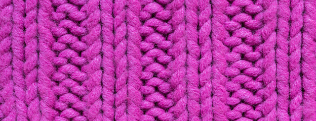 Texture of knitted background with a pattern of pink color close-up long banner
