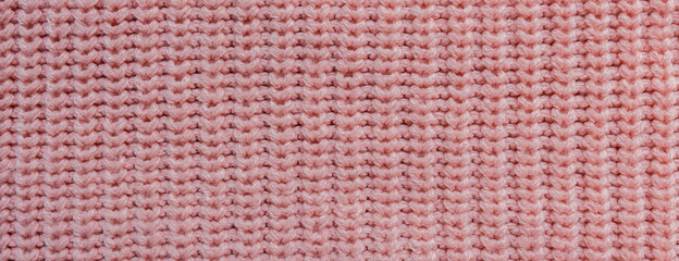 Texture of knitted background with a pattern of pink color close-up long banner