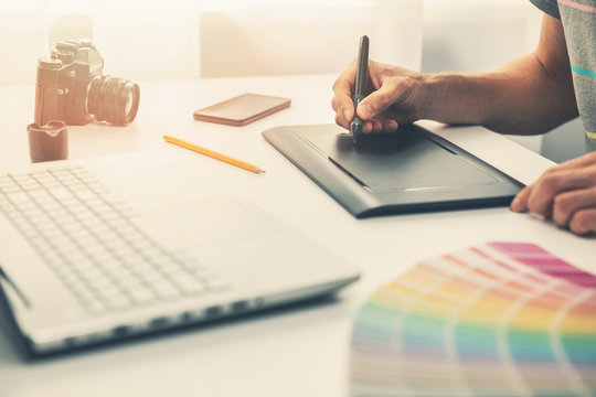 graphic designer at work in office working with digital drawing tablet