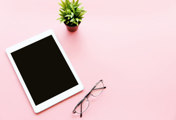 blank Screen tablet And Glasses On the  pink background Copy space