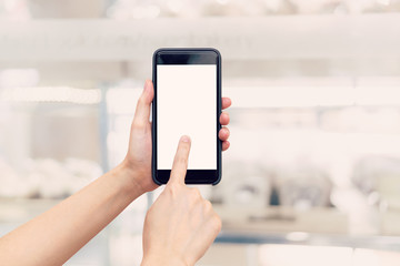 hand woman holding phone with blank screen and blur shopping mall.