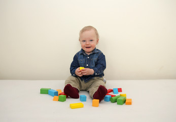 Little boy playing wooden colorful blocks