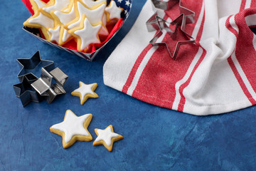 Homemade Star Shaped Sugar Cookies Served in Red, White, and Blue Paper Products against a Blue Background 
