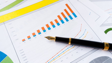 business report with pen statement with graph and data analysis