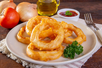 Deep fried onion ring on a wooden background