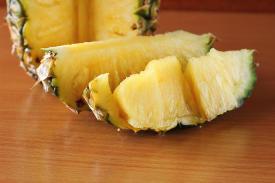 Ripe pineapple and pineapple slices on  wooden