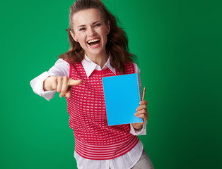 smiling student woman with blue notebook pointing in camera